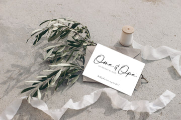 "Oma&Opa" Karte liegt mit einem Umschlag auf einer Pflanze
