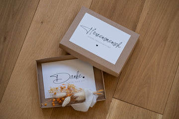 Geschenkbox mit Trockenblumensträußchen, Geschenkbox auf dem Boden, Karte, Holzboden