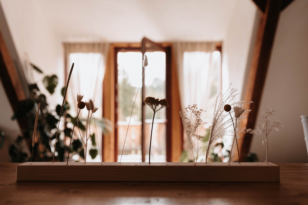 Trockenblumenständer vor einem Fenster