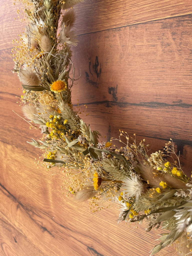 Nahaufnahme eines Trockenblumenkranz der an einer Tür hängt