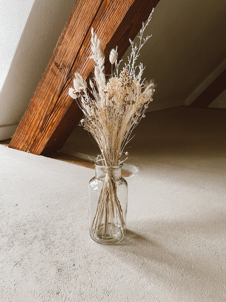 Trockenblumenstrauß in einer durchsichtigen Vase